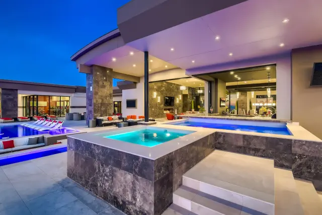 Henderson backyard renovation at dusk with lit pool, spa, and covered patio